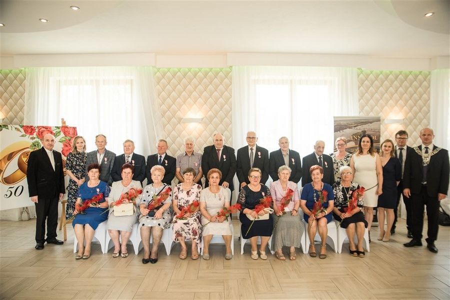 
                                                    Pamiątkowa fotografia Jubilatów obchodzacych Jubileusz Złotych Godów w 2020 r. z Burmistrzem Annopola i zaproszonymi gośćmi.
                                                