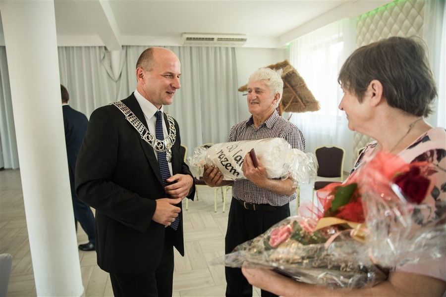 
                                                    Państwo Irena i Kazimierz Mazur otrzymują prezent od Burmistrza Annopola.
                                                
