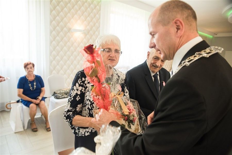 
                                                    Państwo Alina i Zenon Piwowarscy otrzymują prezent od Burmistrza Annopola.
                                                