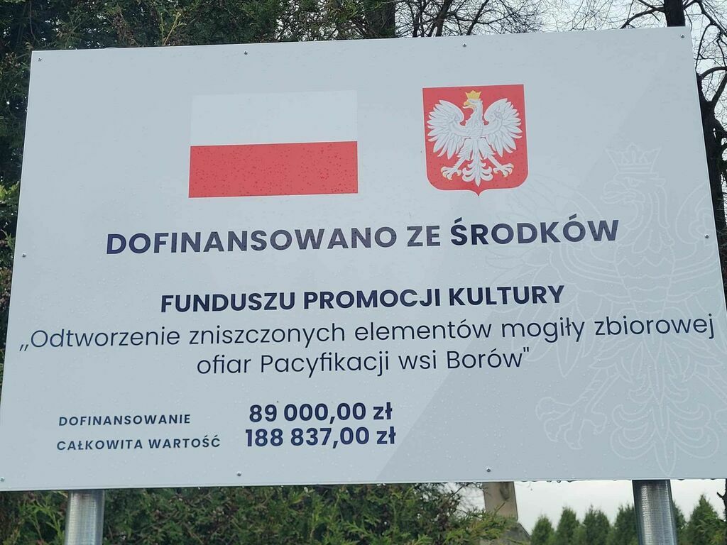 
                                                    Tablica informacyjna: polska flaga, godło, tekst 