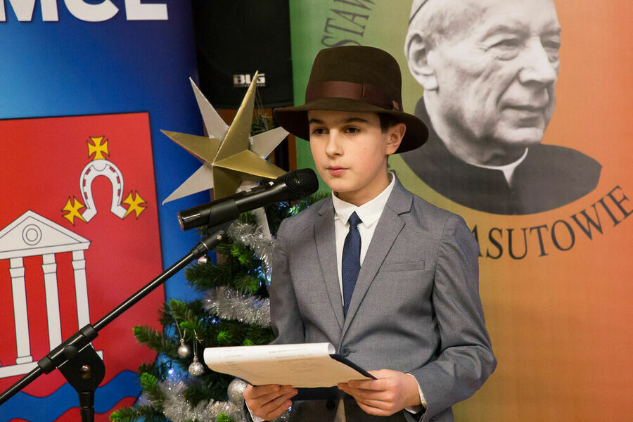 chłopiec w kapeluszu przed mikrofonem