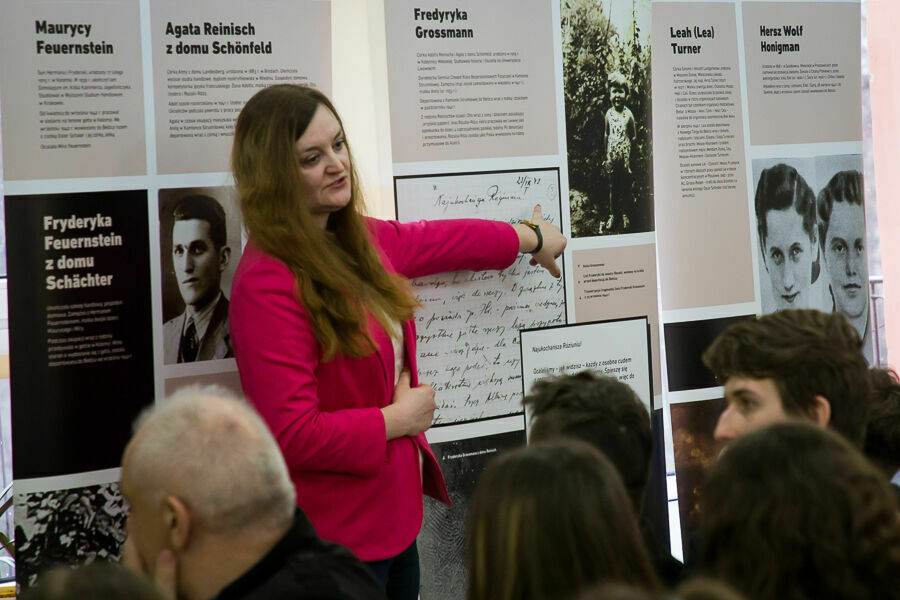 Kobieta przedstawia wystawę materiałów o holokauście