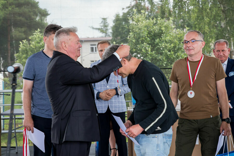 Wójt dekoruje medalem zawodnika