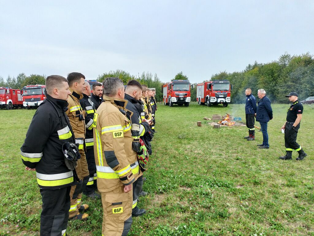 strażacy w dwuszeregu podczas przemowy wójta