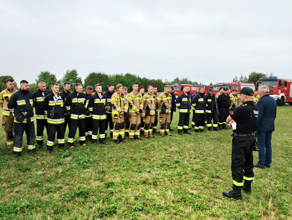 strażacy w dwuszeregu podczas przemowy wójta