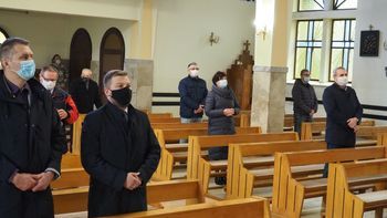 Osoby stojące w kościele podczas mszy