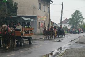 Święty Florian niesiony w deszczu.