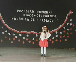 Na zdjęciu są dzieci na scenie śpiewające Piosenki Biało-Czerwonej &quot;Krośniewice i Okolice...&quot;