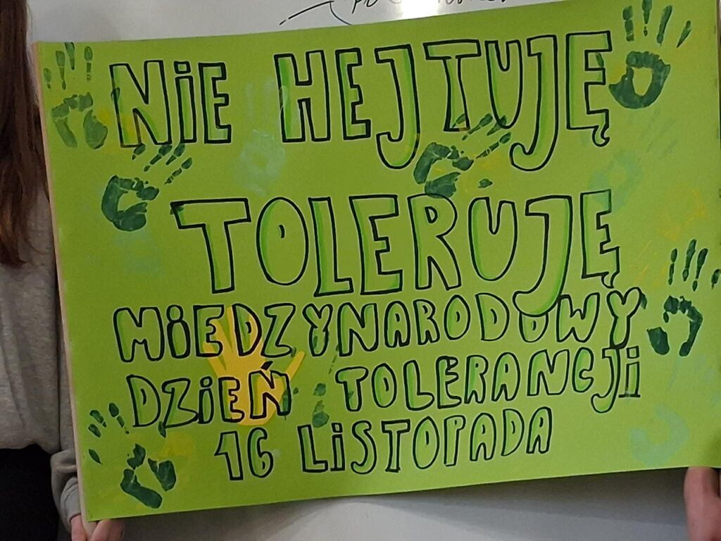 
                                                    Plakat na zielonym tle z hasłem 