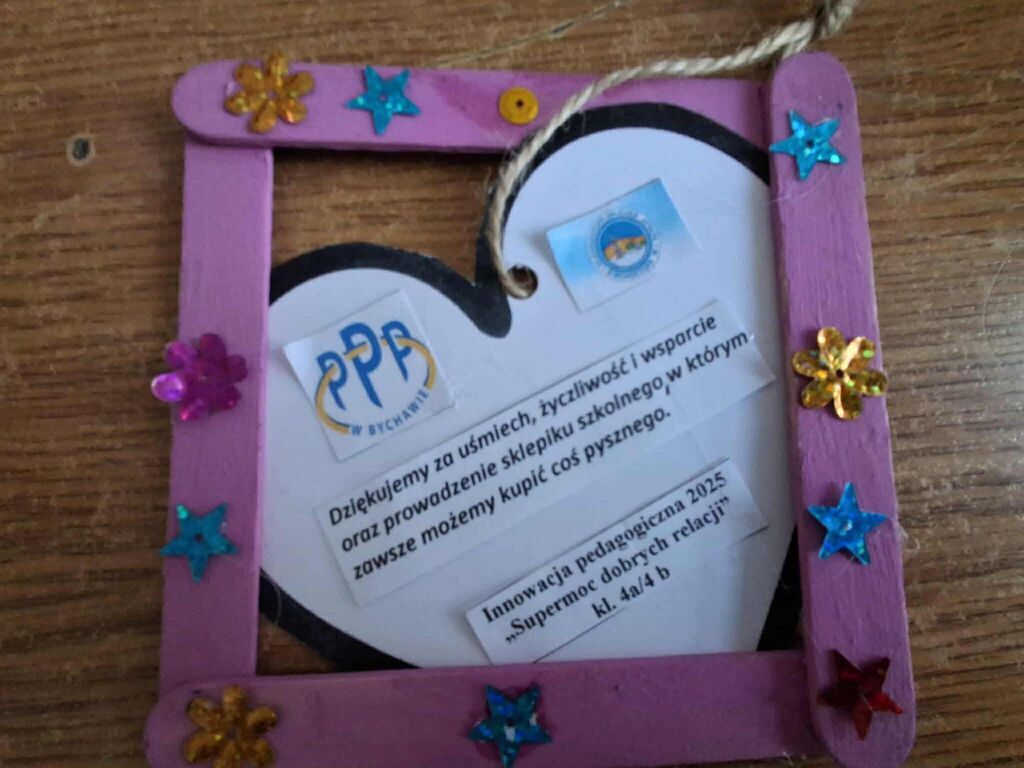 
                                                    Na zdjęciu widnieje dekoracyjna ramka z fioletowych patyczków ozdobiona kolorowymi gwiazdkami i kwiatkami. Wewnątrz znajduje się tekst z podziękowaniem oraz logotypy PPR Bychawa i supermoc dobrych relacji.
                                                