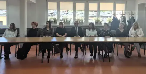 
                                                    Uroczystość w Starostwie Powiatowym w Rykach. Nagrodzeni nauczyciele i pracownicy oświaty z kwiatami i dyplomami pozują z władzami powiatu na tle granatowej ścianki z napisem Powiat Rycki.
                                                