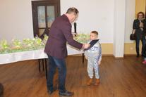 Burmistrz przekazujący upominek chłopcu