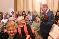 Grupa ludzi na publiczności- wręczenie kobietom kwiatów