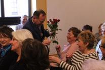 Grupa ludzi na publiczności- wręczenie kobietom kwiatów