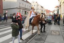 grupa ludzi i prowadzący ją Królowie na koniach 