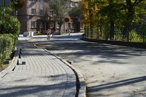 Zdjęcie przedstawia chodnik w trakcie remontu. Po lewej stronie chodnik z kostki brukowej, po prawej jezdnię.