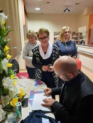 Mariuszem Kurcem podpisujący swoją autorką książkę.