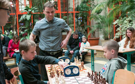 zawodnicy grają w szachy, w tle prezes Gońca Żarów Artur Adamek