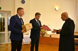 Burmistrz leszek Michalak i zastępca burmistrza Przemysłąw Sikora przekazują upominek na ręce ks. Ryszarda Mencla