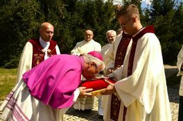 biskup całuje krzyż
