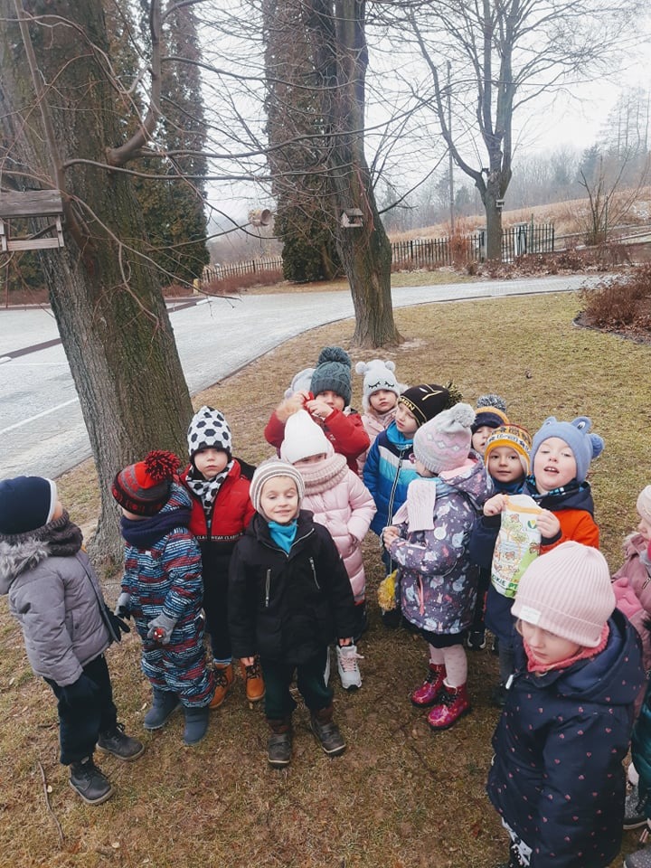 Przedszkolaki dokarmiają ptaki zimą