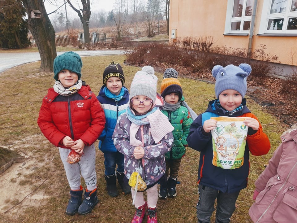 Przedszkolaki dokarmiają ptaki zimą