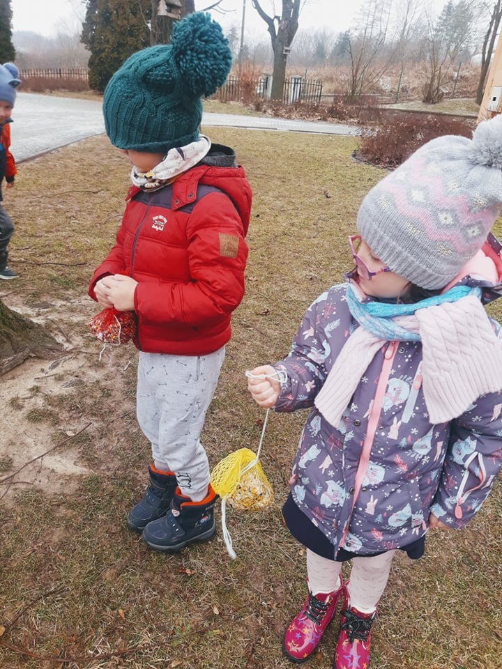 Przedszkolaki dokarmiają ptaki zimą