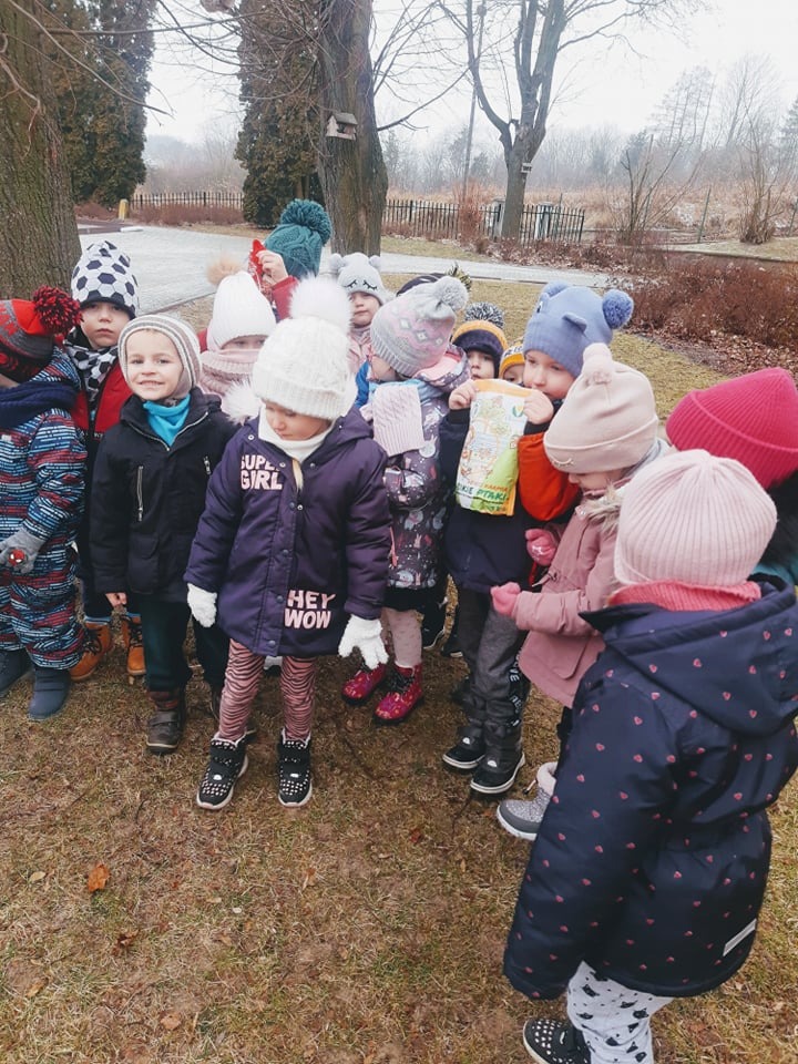 Przedszkolaki dokarmiają ptaki zimą