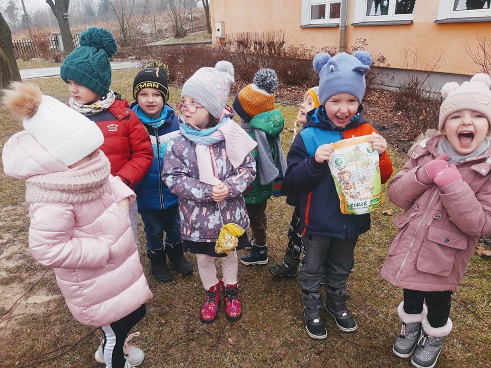 Przedszkolaki dokarmiają ptaki zimą