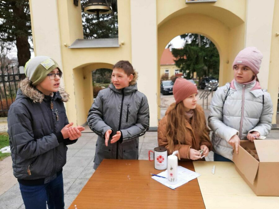 Hirek, Patryk, Lena i Zuzia sprzedają świece Caritas