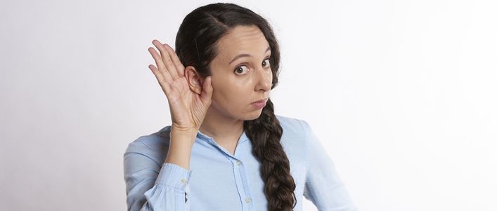 Kobieta z ręką przy uchu- nasłuchiwanie
