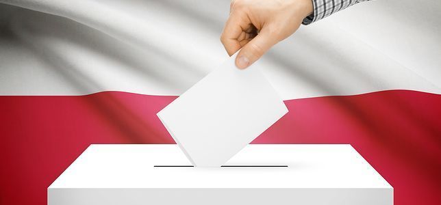 Urna do głosowania na tle flagi Polski