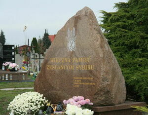 Kamień nagrobny w kształcie dużego, naturalnego kamienia z wyrytym królikiem i dedykacją "Wieczna pamięć Zasłużonemu Królikowi" oraz datami.