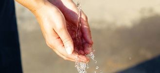 kobiece dłonie łapiące wodę