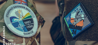 Na zdjęciu widać ramię osoby w mundurze wojskowym z naszywkami: emblemat NATO, insignia ćwiczeń STEADFAST DEFENDER 2021 i DRAGON 24. #DRAGON24 #DGRSZ