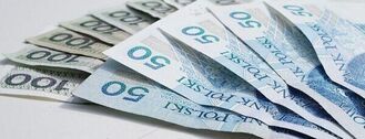 Fani banknotów rozmieszczone na białym tle, skupiając się na jednym z przodu z rozmazanymi banknotami w tle.