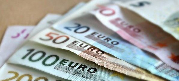 Kilka banknotów euro rozłożonych na stole, w tym nominały 5, 20, 50, 100, 200 i 500 euro. Banknoty są ułożone jeden na drugim, ukazując różnorodność kolorów i wzorów.