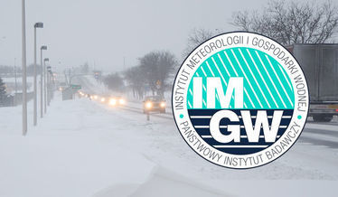 Zdjęcie przedstawia logo IMGiW na tle opadów śniegu