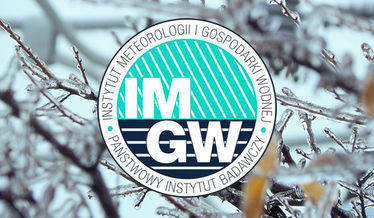 Zdjęcie przedstawia logo IMGW na tle oblodzonych gałęzi