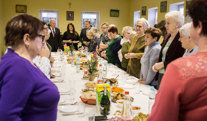 Zdjęcie grupowe członków Klubu Seniora w Niemcach przy stole