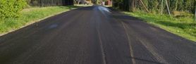 Zdjęcie przedstawia nowowylany asfalt na drodze 