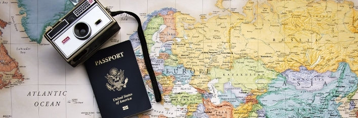 Mapa świata a na niej leży paszport i aparat