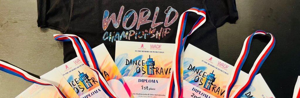 Na zdjęciu czarna koszulka z napisem "World Championship" oraz zestaw pięciu dyplomów i medali z zawodów tanecznych w Ostrawie, w tym nagrody za pierwsze i drugie miejsca.