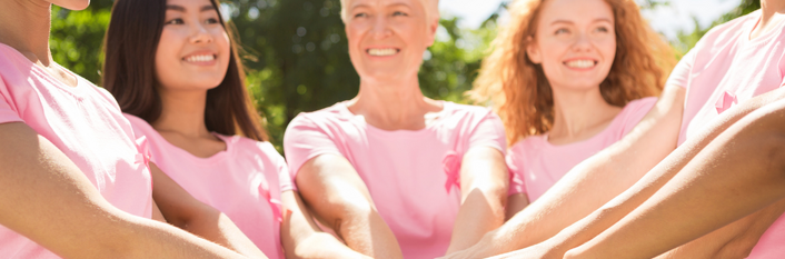 Grupa kobiet w różowych koszulkach stoi w kręgu, każdy kładzie rękę na rękach innej osoby, symbolizując jedność. Na dole napis o bezpłatnej cytologii dla mieszkanek Lubelszczyzny.