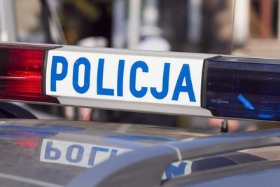 Fragment radiowozu z napisem POLICJA