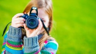 Dziewczynka robiąca zdjęcie aparatem fotograficznym