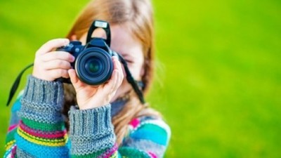 Dziewczynka robiąca zdjęcie aparatem fotograficznym