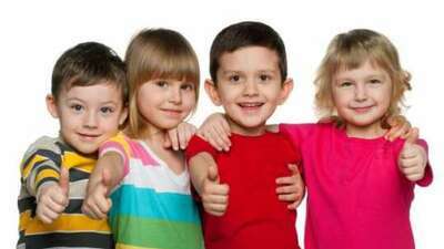 Czwórka dzieci stojących obok siebie podnoszących lewy kciuk do góry