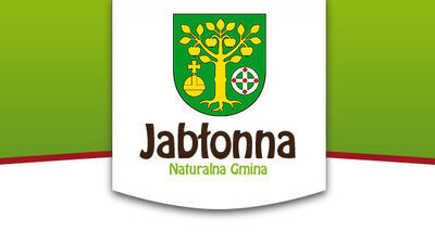 Herb Jabłonny przedstawia złote drzewo z owocami na zielonym tle, pod nim jabłko oraz tarczę. Poniżej napis "Jabłonna Naturalna Gmina" w brązowo-zielonej kolorystyce.