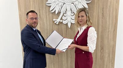 zdjęcie dwóch osób trzymających dokument